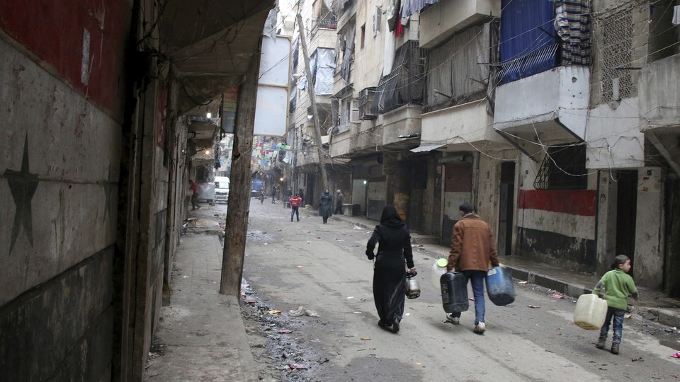 Civilians walk down a street in Aleppo, Syria, on August 11.