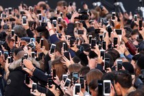 A crowd of people taking photos with smartphones
