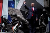 U.S. President Donald Trump waves on stage in front of a national monument before his speech in Warsaw, Poland