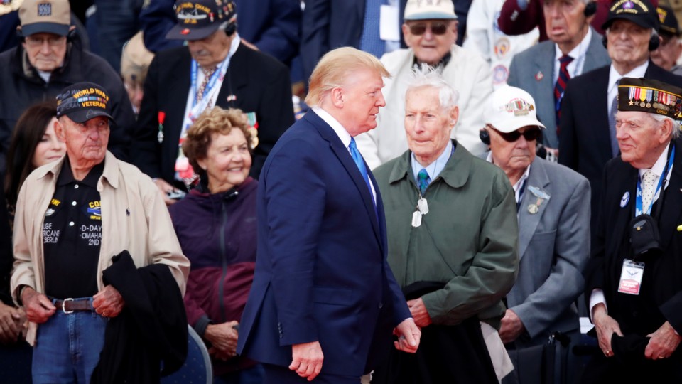 Donald Trump walks past World War II veterans at a D-Day ceremony in Normandy.