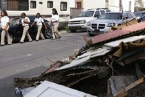 Students walk next to a pile of debris. 