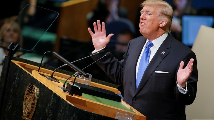 President Donald Trump is shown on a large screen.