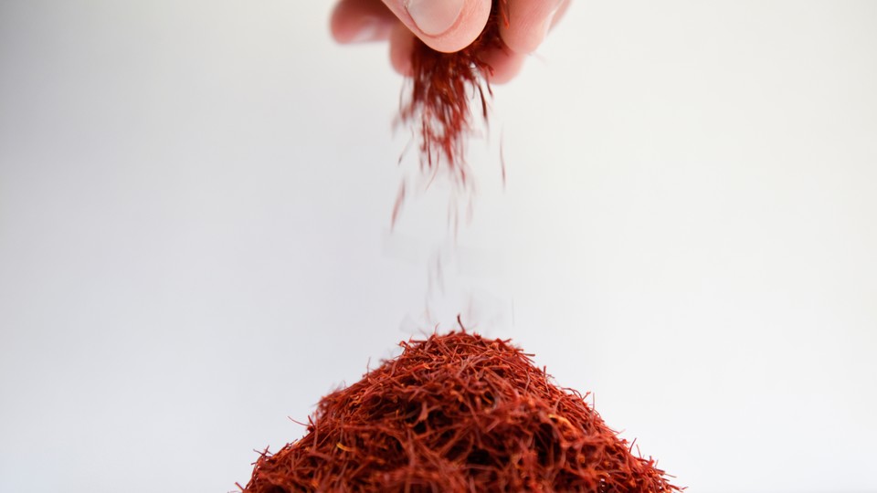 A hand sprinkles saffron into a pile.