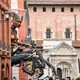 A giant mechanical puppet of a mythical human-scorpion creature moves through a narrow street.