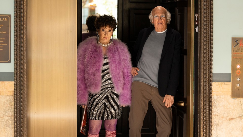 Larry David and Susie Essman stand in a doorway