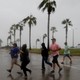 A group races across the street as winds from Hurricane Harvey escalate in Corpus Christi, Texas, on August 25, 2017.