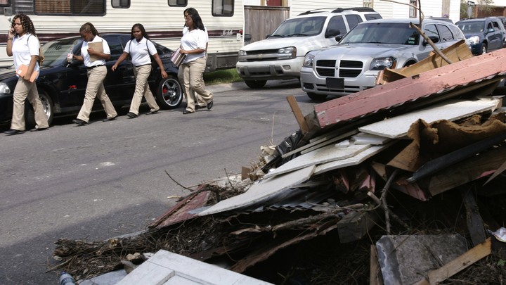 Students walk next to a pile of debris.