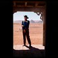 John Wayne stands alone in a doorway