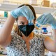 A researcher examining vials in a lab