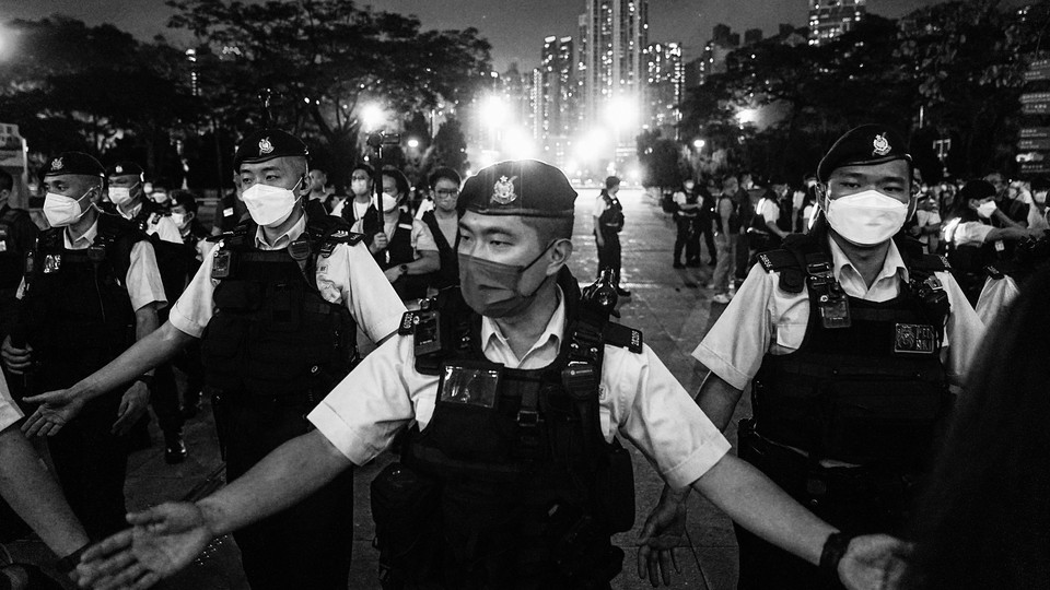 Police officers disperse people at Victoria Park on the anniversary of the Tiananmen Square crackdown.