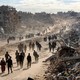 Photo of people walking past rubble in the Gaza Strip