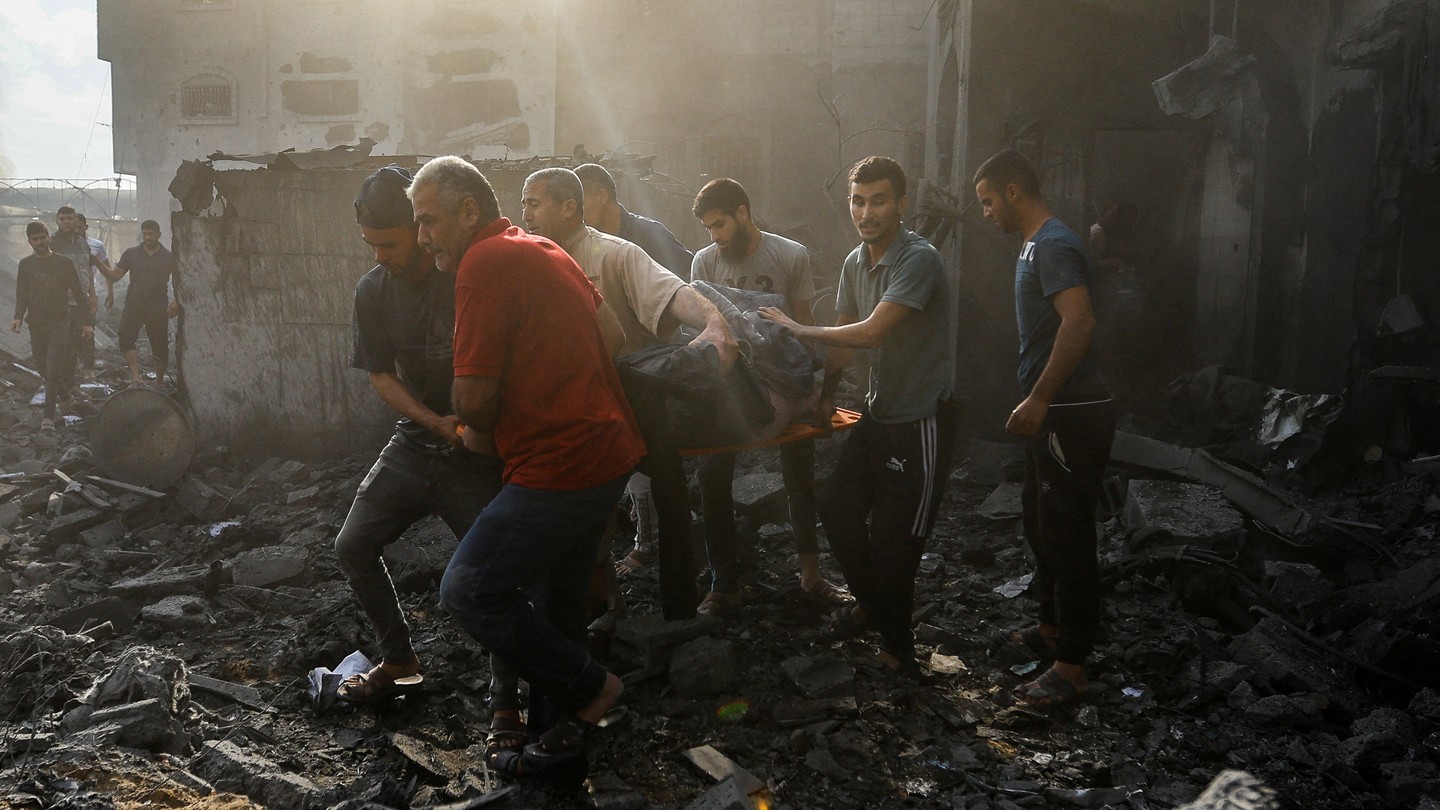 Picture of Palestinians carrying a casualty from the rubble in the aftermath of Israeli strikes in Khan Younis, in the southern Gaza Strip, on October 11, 2023.