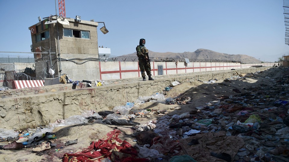 A Taliban fighter stands guard at the site of the August 26 twin suicide bombs