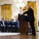 A photo of President Trump delivering a White House speech to an audience.