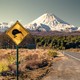 A kiwi crossing sign in a mountain valley