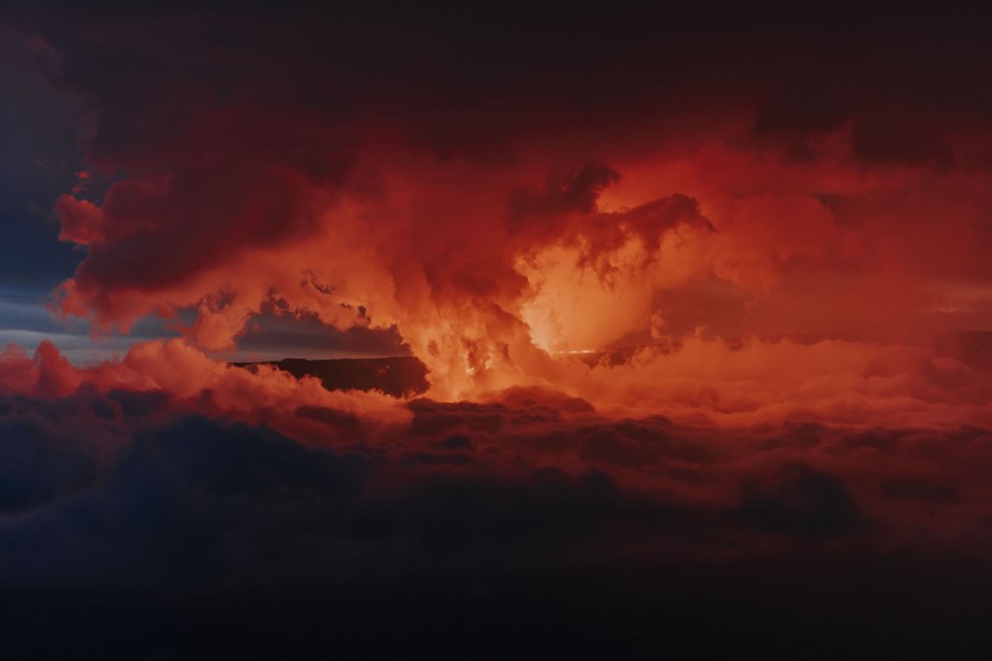 Clouds glow during a volcanic eruption at night.