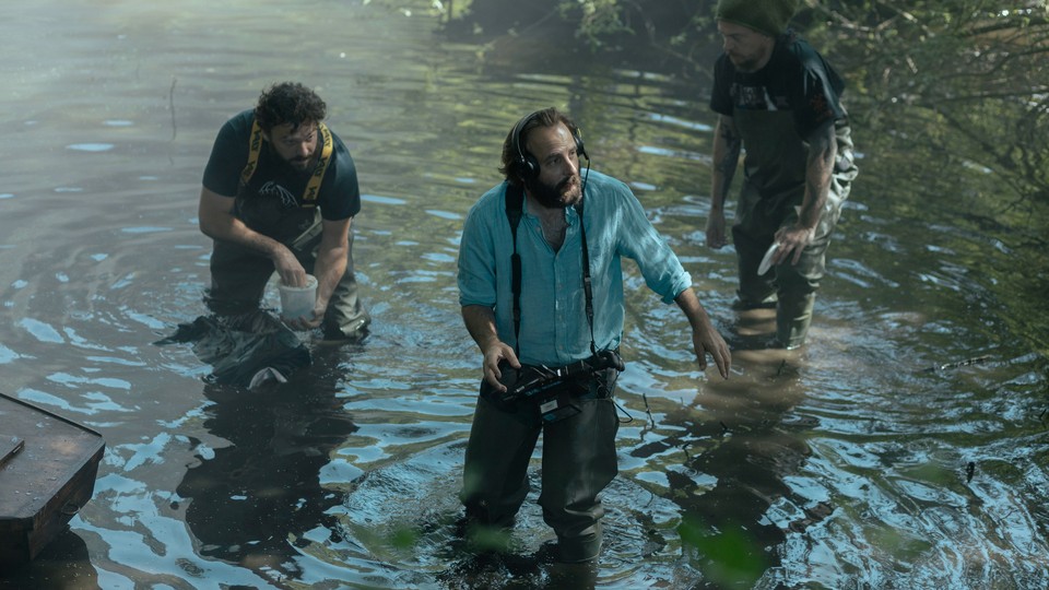 Vincent Macaigne as René the director, in the water with crew members, in 'Irma Vep'