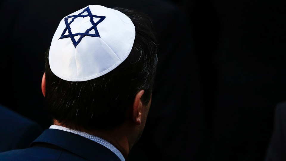 A man wearing a white yarmulke with a blue Star of David