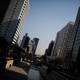 A man walks along a canal next to skyscrapers