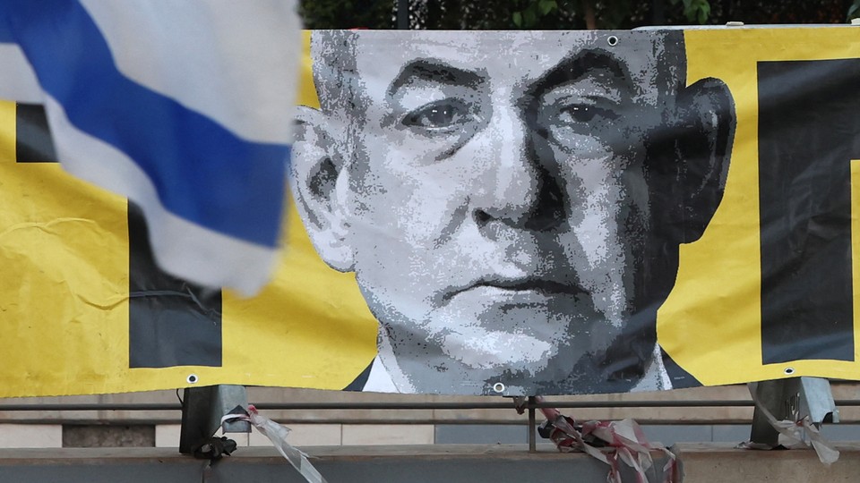 A stylized, pixelated image of Netanyahu is shown on a yellow banner, with a piece of an Israeli flag flying in the foreground