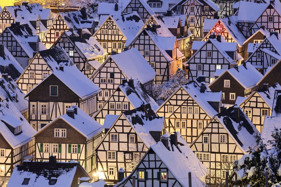 A neighborhood of old European half-timbered houses, photographed after a snowfall.