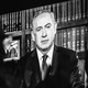 Black-and-white photo of an onlooker watching a speech by Benjamin Netanyahu