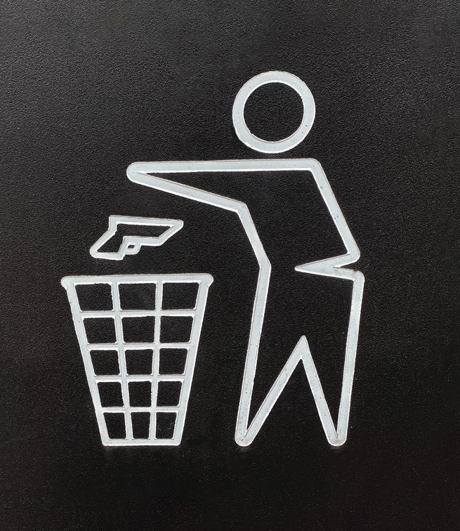 Sign with "Don't Litter" sign-style outline of person throwing gun into trash