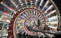 The interior of a bookstore, looking down a tunnel made of spiraling bookshelves