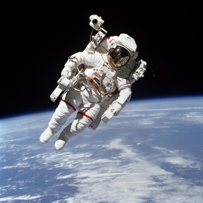 Bruce McCandless floats in space, with the earth in the background.