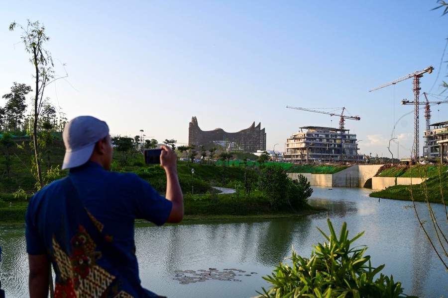 A man takes photos of buildings under construction.