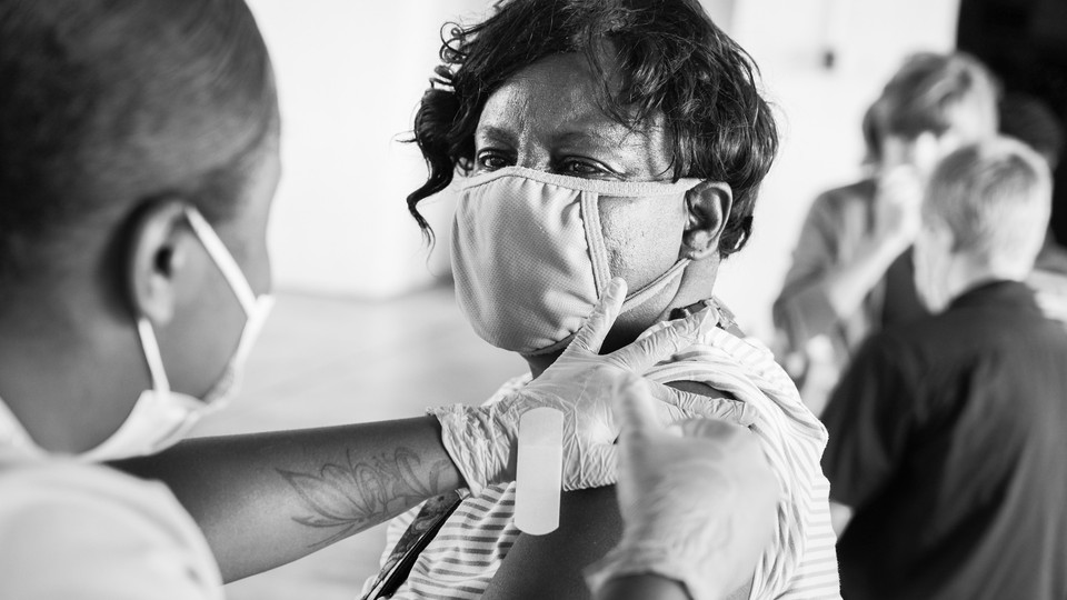 A man in a mask getting a vaccine