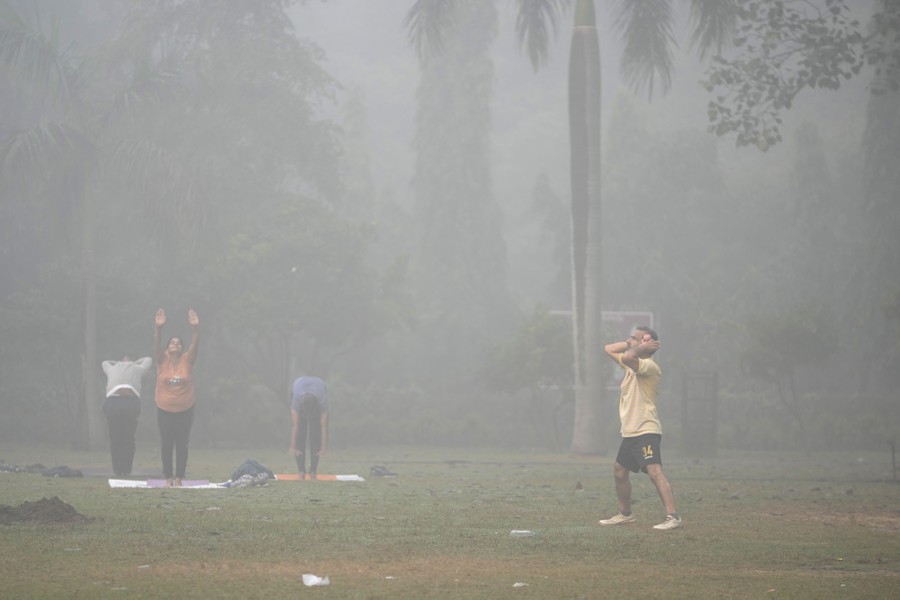 Several people exercise in a park, surrounded by smog.