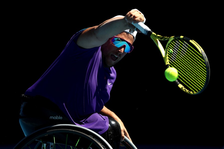 Dylan Alcott serves a ball from his wheelchair.