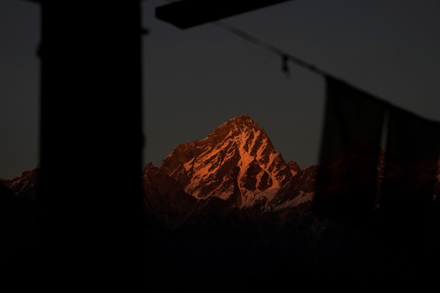 A snowy mountain peak bathed in warm sunset light
