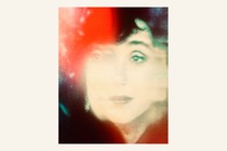 A colorful photograph of a projected image of Cher