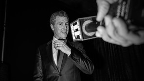 Black and white photo of Gavin Newsom in front of a mic