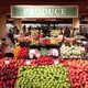 People walk through the produce department at a grocery store