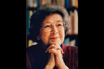 A photo of Beverly Cleary smiling, resting her chin on her clasped hands