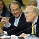 Alan Simpson speaks as Erskine Bowles looks on