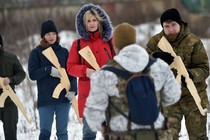 A military instructor teaches civilians holding wooden replicas of Kalashnikov rifles in Kyiv on February 6, 2022.