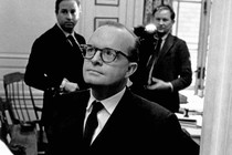 Black-and-white photo of Truman Capote holding copies of his book "In Cold Blood"