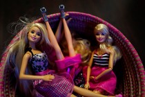 Barbie dolls sit in a basket