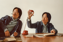 doubled photo with Jimmy O. Yang lying on desk with pen as mustache next to Jimmy adjusting a desk lamp