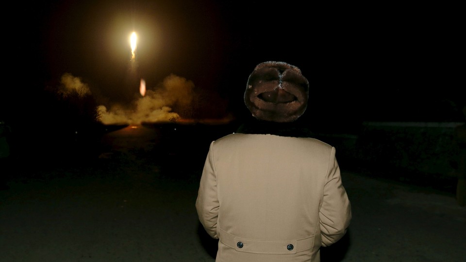 North Korean leader Kim Jong Un watches as a missile takes off. 