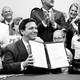 Ron DeSantis holding up a signed bill