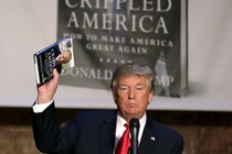 Donald Trump holding up a copy of his book "Crippled America"