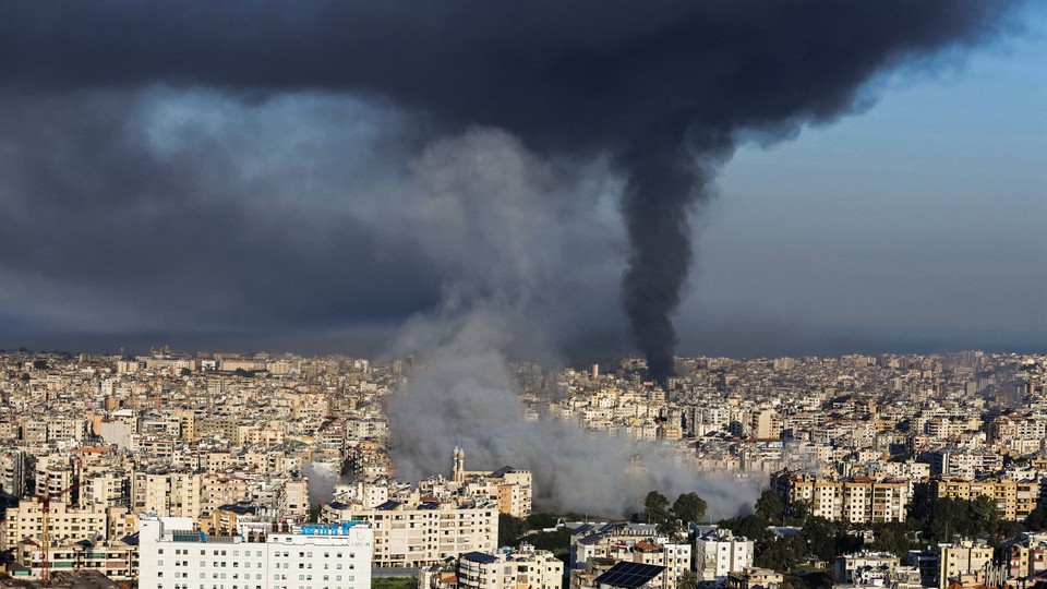 Photograph of plumes of black smoke rising above Beirut