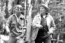 Robert F. Kennedy and Supreme Court Justice William O. Douglas hiking through the woods wearing outdoors gear.