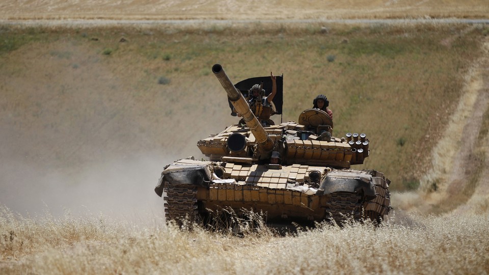 Members of Jabhat al-Nusra drive a tank in Syria.