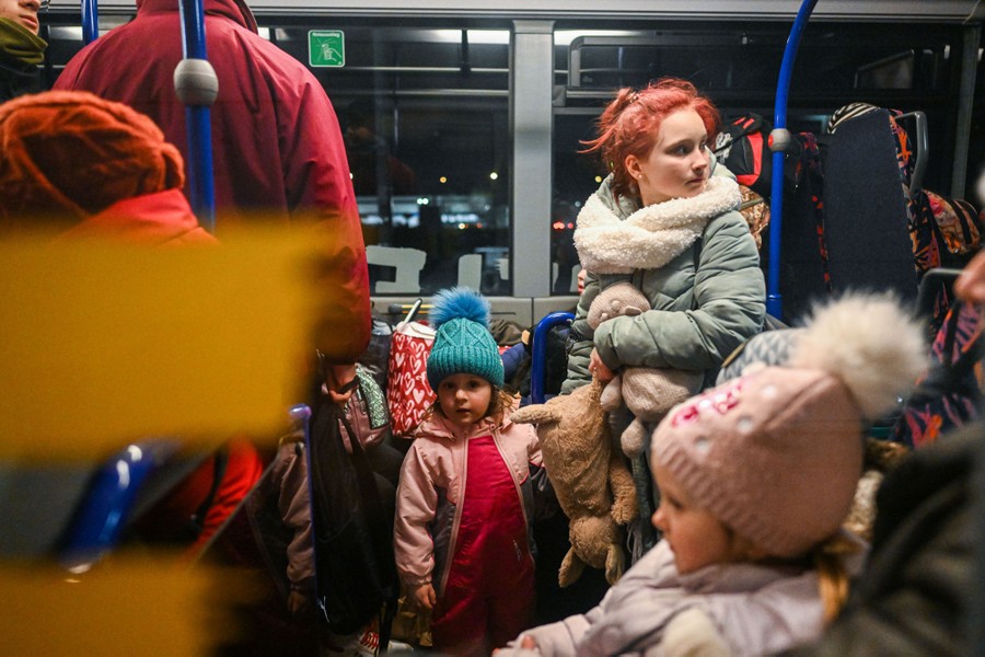 Adults and children board a bus.